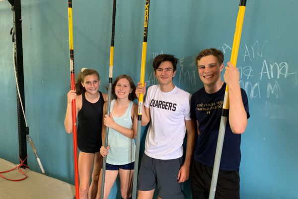 Four young vaulters with poles