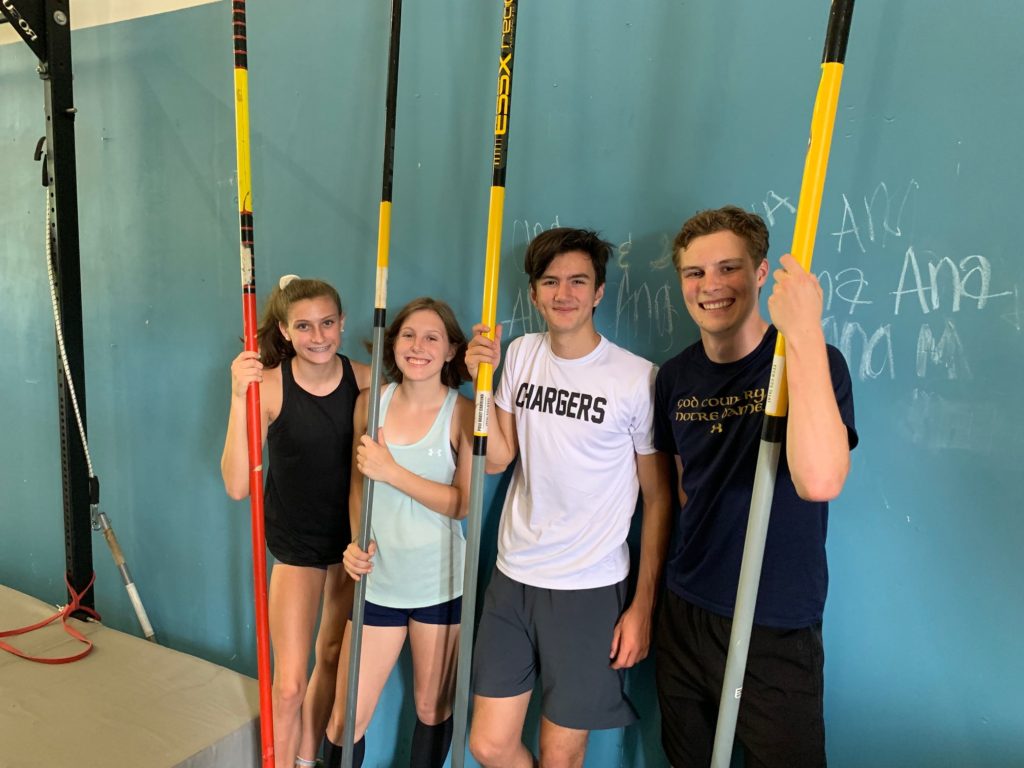 Four young vaulters with poles